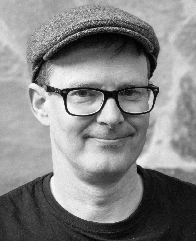 En svartvit porträttbild av Jesper Grönholm.